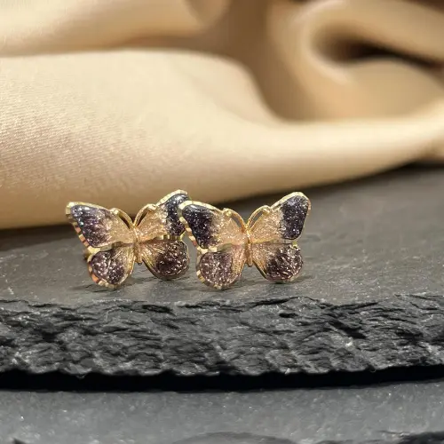 Jubiler Kraków Sklep – Pierścionki, Obrączki, Biżuteria BigDIAMOND 6 Złote kolczyki motyle wykonane przez firmę jubilerską BigDIAMOND na tle kamienia