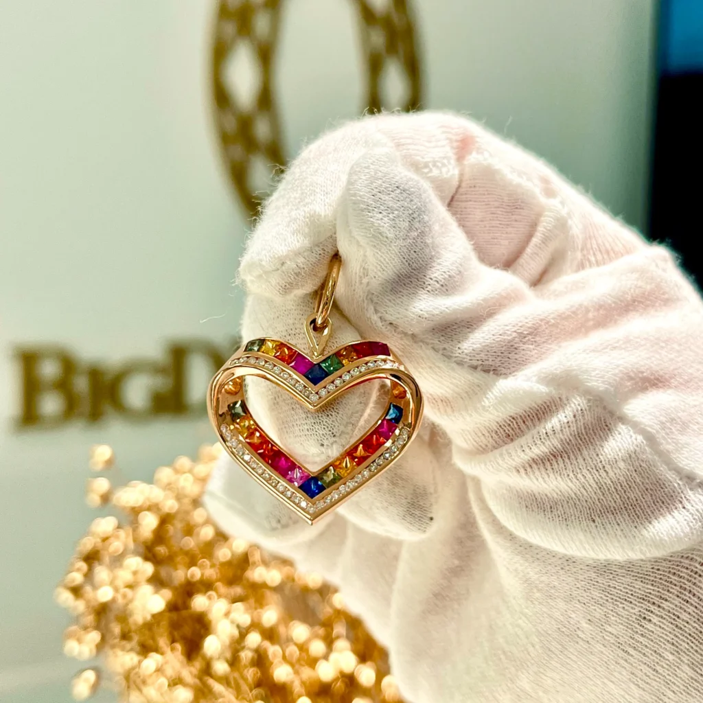 Kolczyki Handmade Kraków – Wyjątkowa Biżuteria Ręcznie Robiona od BigDIAMOND 16 Złoty wisiorek serce z kolorowymi kamieniami trzymany w rękawiczce