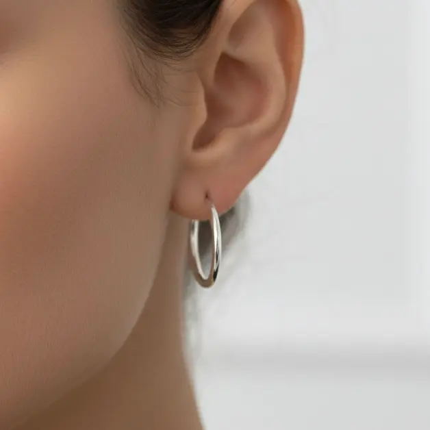 Srebrne kolczyki koła cienkie klasyczne (kółka) | BigDIAMOND Jubiler Krakow 1 Earrings in the shape of thin hoops worn by a model.