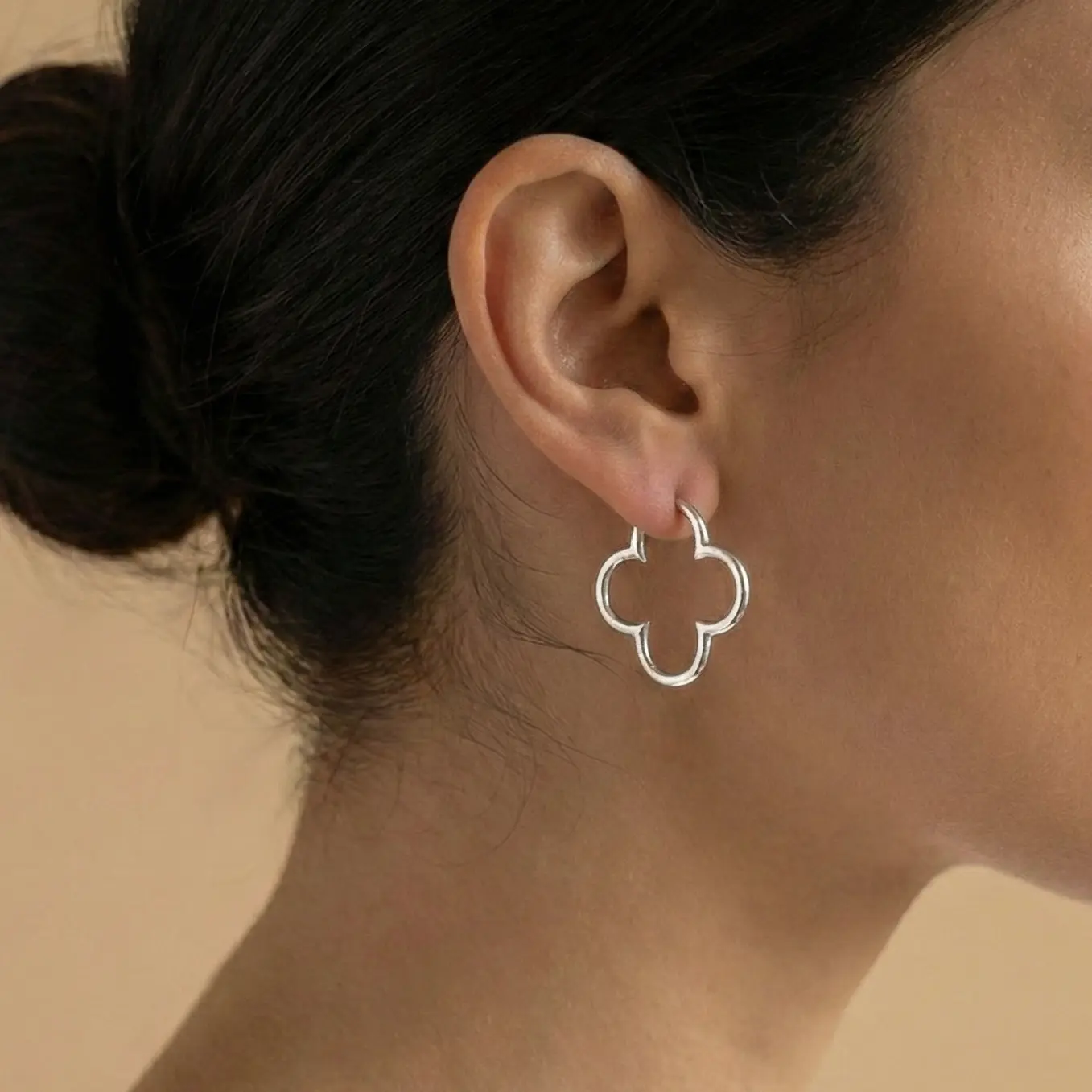 Srebrne kolczyki koniczyna ażurowe na kółko | BigDIAMOND Jubiler Krakow 1 A model showcasing silver clover-shaped earrings.