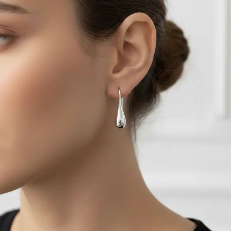 Srebrne kolczyki wiszące krople minimalistyczne srebro 925 | BigDIAMOND Jubiler Krakow 1 Kolczyki wiszące w kształcie kropli na uchu modelki.