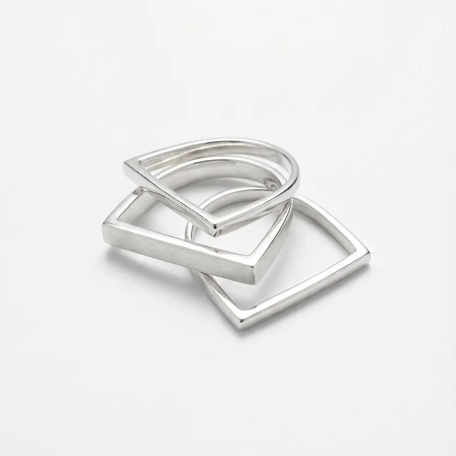 3 Srebrne pierścionki, geometryczne kwadraty minimalistyczne | BigDIAMOND Jubiler Krakow 3 Nowoczesne pierścionki geometryczne w srebrnym kolorze, ułożone obok siebie.